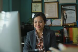 Pria atau wanita muda Indonesia duduk sendiri di kantor modern dengan ekspresi hampa meski terlihat profesional, menggambarkan krisis identitas dan kehilangan arah hidup.
